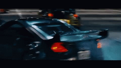 Animated GIF featuring a scene from Fast and Furious: Tokyo Drift - cars drifting between traffic.